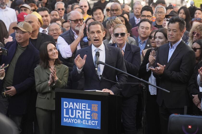 Daniel Lurie, middle, speaks at a news conference next to his wife, Becca Prowda, middle left, in San Francisco, Friday, Nov. 8, 2024. (AP Photo/Jeff Chiu)