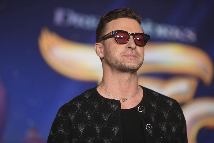 Justin Timberlake in a black jacket and red tinted sunglasses at the 2023 premiere of "Trolls Band Together" in L.A. 