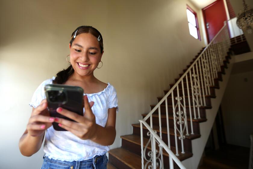 LOS ANGELES, CA - JULY 2, 2024 - Angelica Zamora-Reyes, 17, a senior at Downtown Magnets High School works on her smart phone at her home in Los Angeles on July 2, 2024. Starting in 2025 LAUSD will initiate a new policy banning cell phones during the school day. Zamora-Reyes agrees with the new policy. (Genaro Molina/Los Angeles Times)