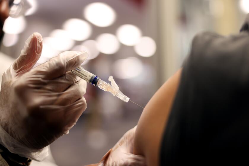 HUNTINGTON PARK-CA-AUGUST 28, 2024: Brandon Guerrero, 34, of Compton, receives both a flu and COVID-19 vaccine at CVS in Huntington Park on August 28, 2024. (Christina House / Los Angeles Times)