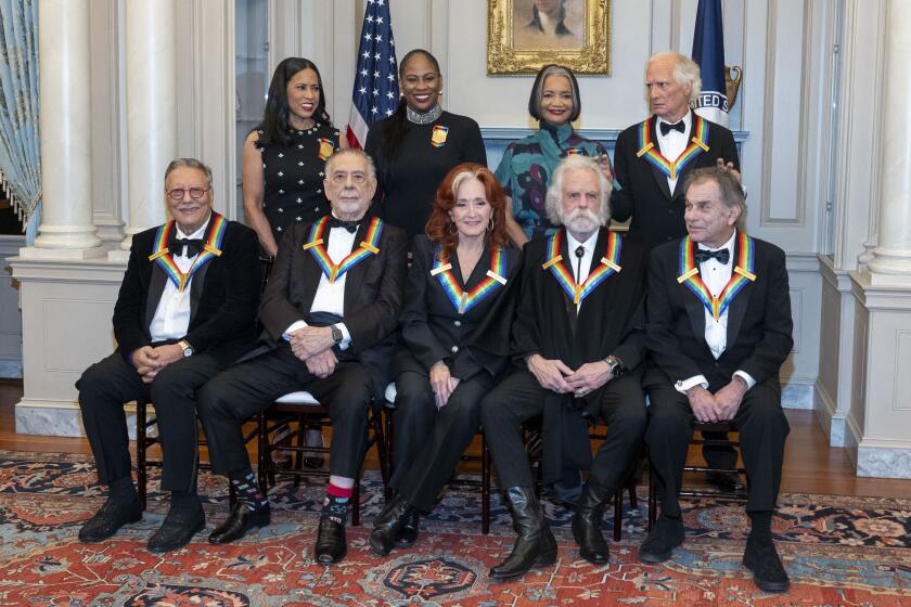 Billy Kreutzmann, top right, gives bunny ears to his Grateful Dead bandmates during a group photo of the 2024 Kennedy Center Honorees at the State Department for the Kennedy Center Honors Dinner, Saturday, Dec. 7, 2024, in Washington. In photo with Kreutzmann are, front row from left, Arturo Sandoval, Francis Ford Coppola, Bonnie Raitt, Bobby Weir, Mickey Hart; second row from left, Michelle Ebanks, Kamilah Forbes, Jonelle Procope, and Kreutzmann. (AP Photo/Kevin Wolf)