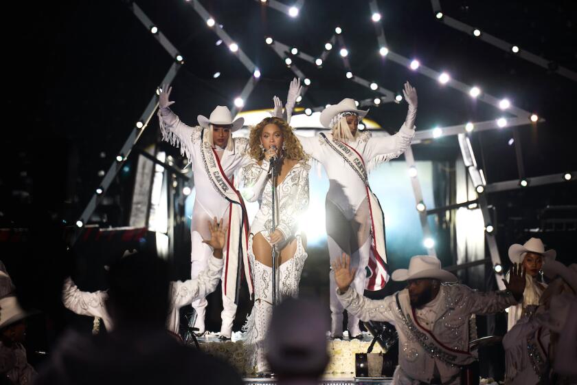 A pop star in a white outfit performs live.