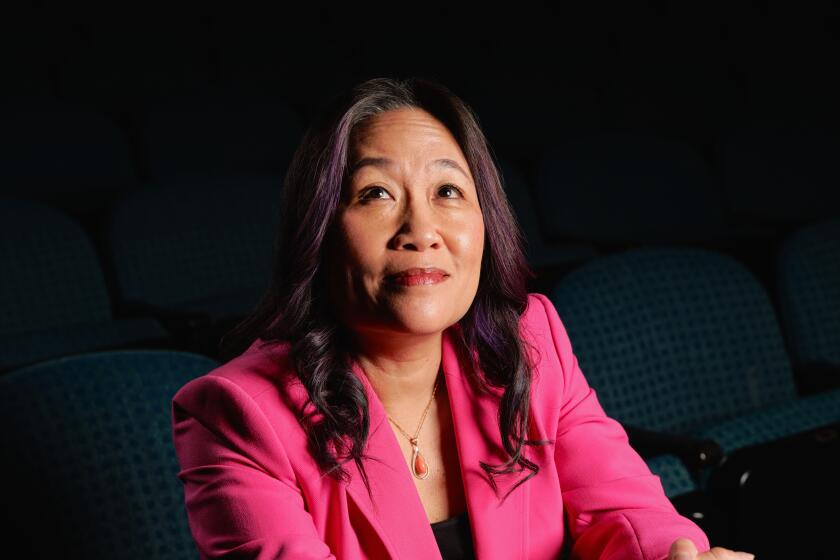 A woman seated in a theater looking up