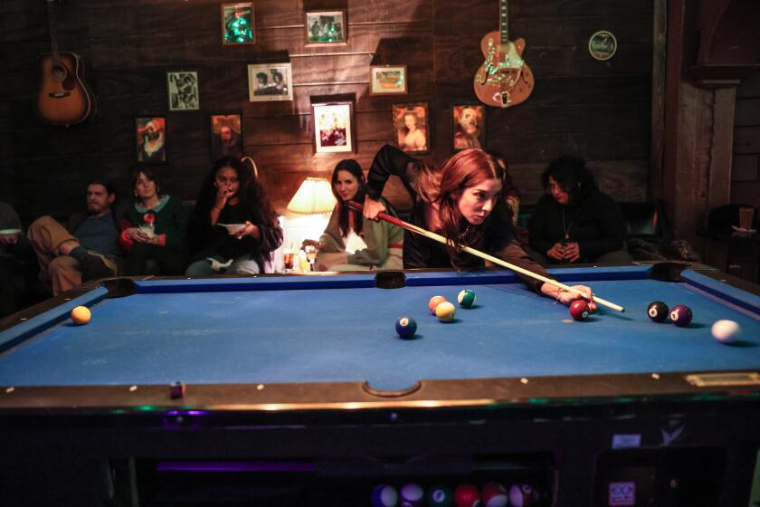 Los Angeles, CA, Tuesday, Dec. 10, 2024 - Nka Belinsky lines up a shot as others look on The infamous Silverlake Gen-Z TikTok bar 4100 hosts a queer, female-forward pool tournament on Tuesday nights called Please Be Nice to Me. The pool night was born when Andrea Lorell and Julianne Fox wanted to start playing pool but experienced a lot of aggressive male energy surrounding the sport in other bars. (Robert Gauthier/Los Angeles Times)