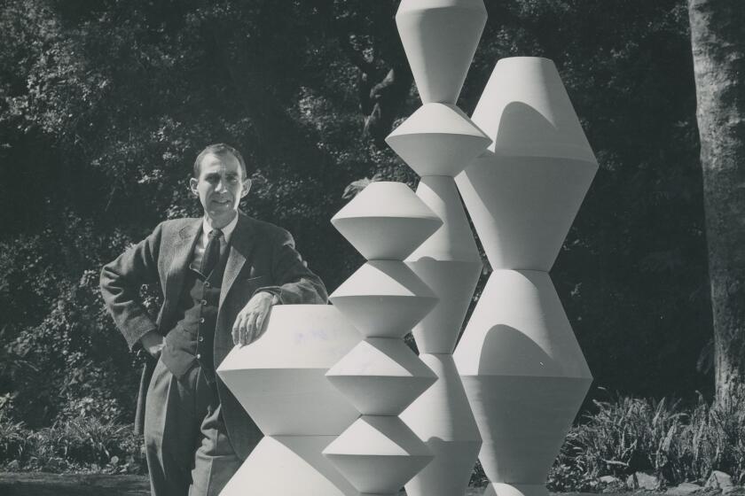 A 1957 photo of LaGardo Tackett with Totems he designed for Architectural Pottery.